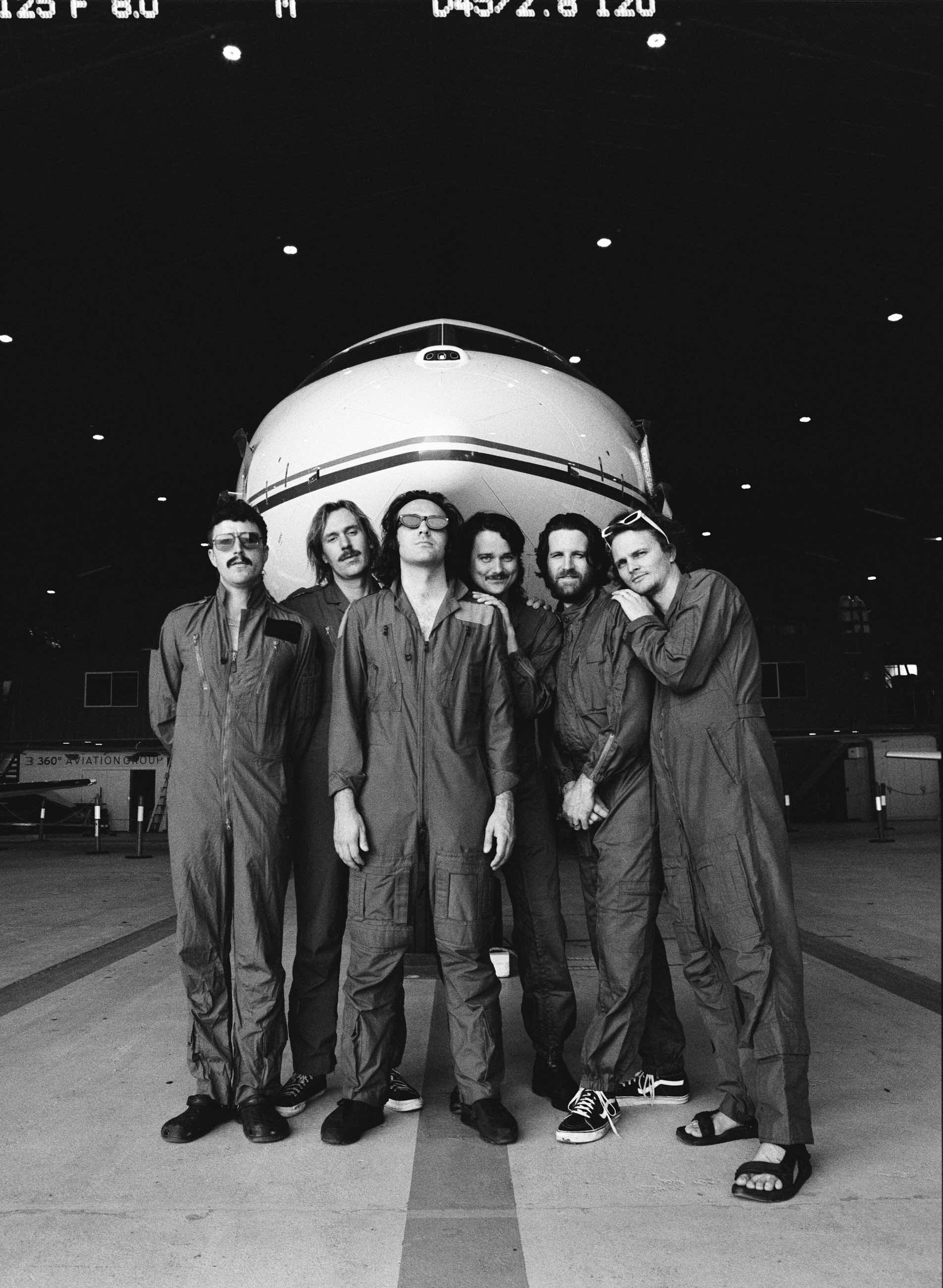 King Gizzard & the Lizard Wizard in posa davanti a un aereo