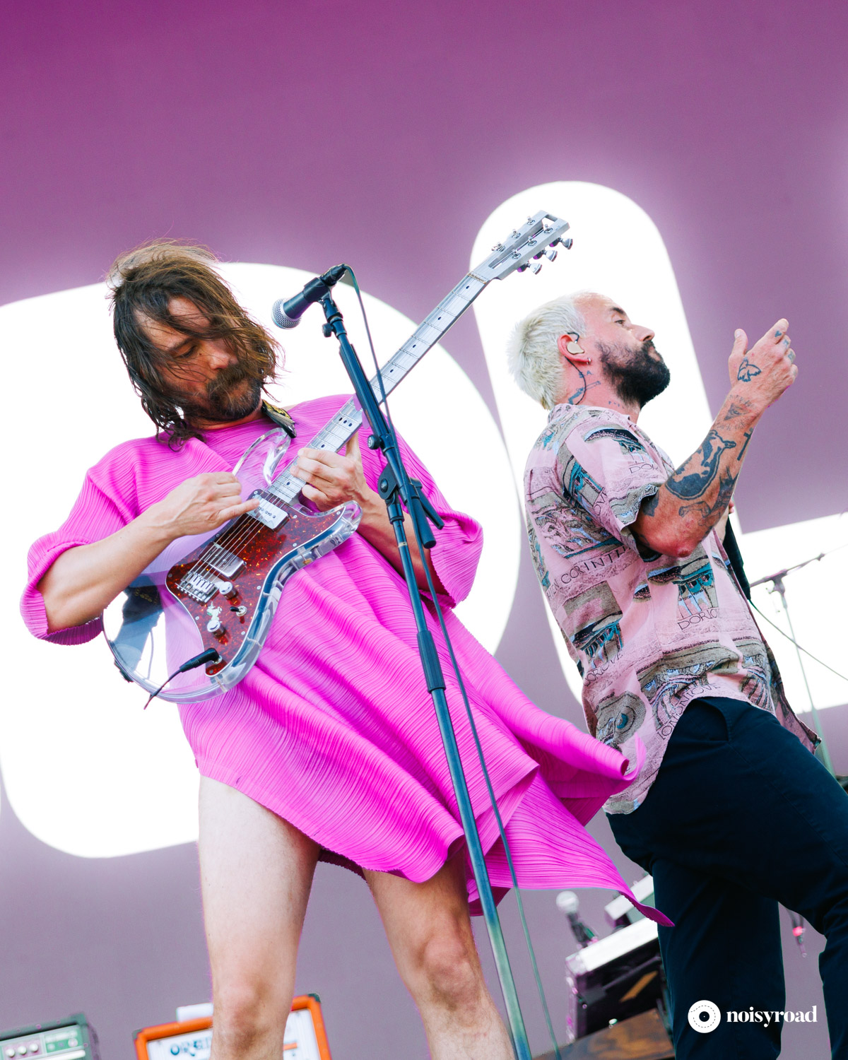 Mark Bowen e Joe Talbot degli IDLES in concerto agli I-Days Milano 2026 Mark Bowen con il vestito rosa e Joe Talbot degli IDLES sul palco degli I-Days Milano 2026